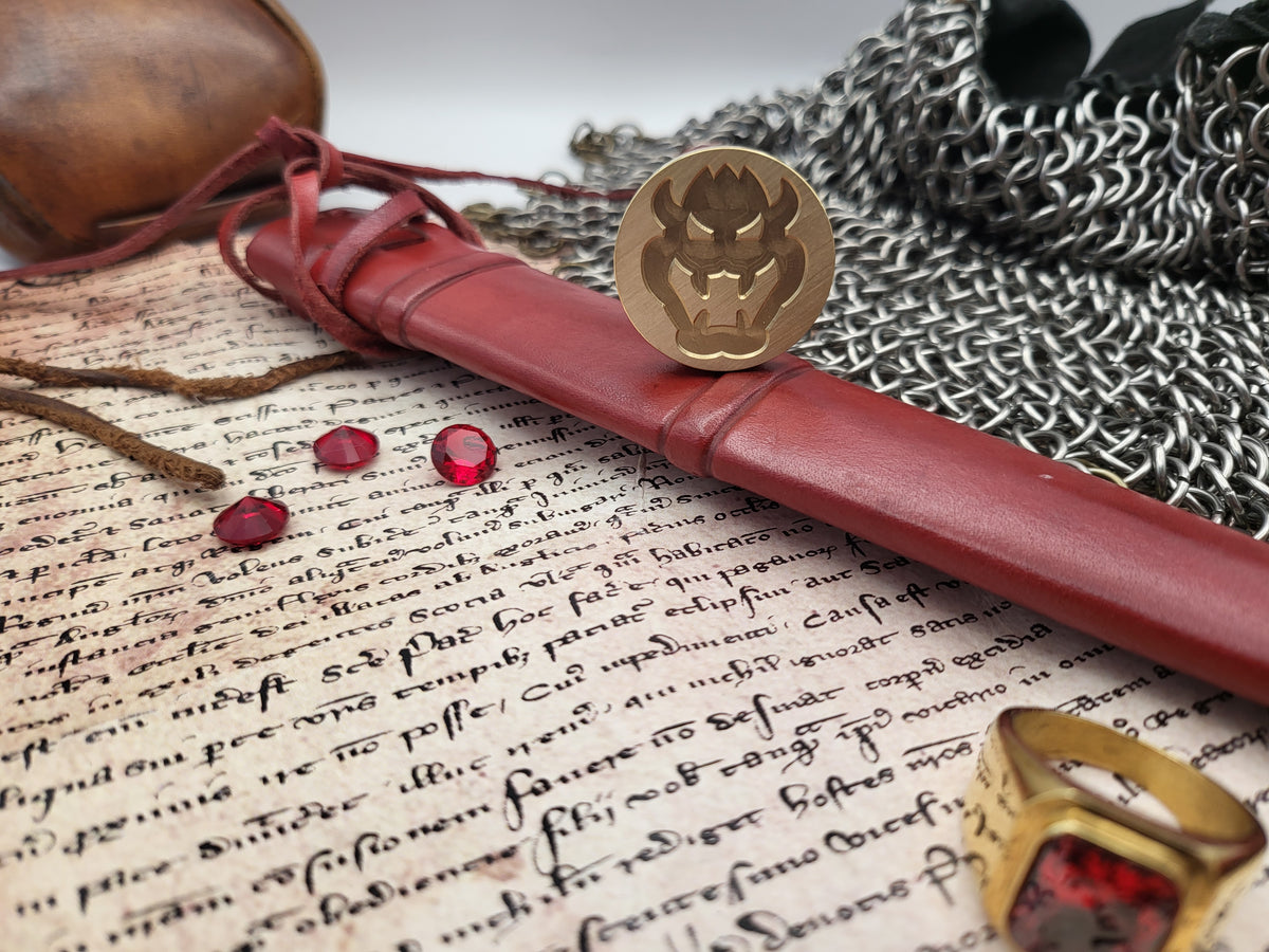 A fantasy-themed sheath set displayed on an aged manuscript, surrounded by thematic props including a chainmail cloak, a wooden shield, red gemstones, and a gold ring.
