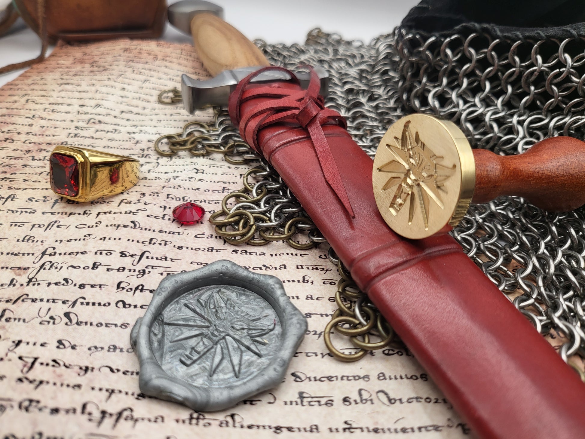 Witcher Wolf wax seal impression in red sealing wax beside the brass stamp.